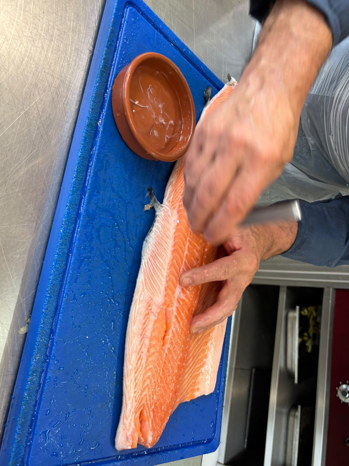 Le chef lève un filet de saumon